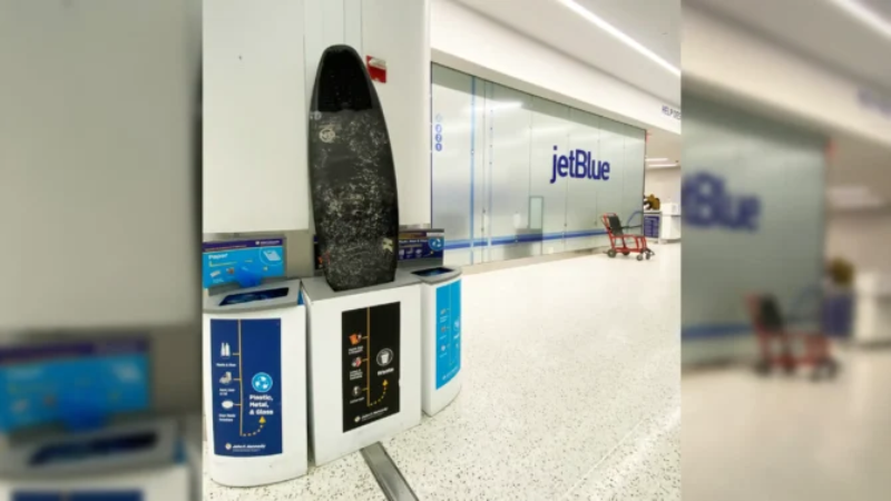 Surfboard abandoned in a trash can at the JetBlue counter at JFK Airport.